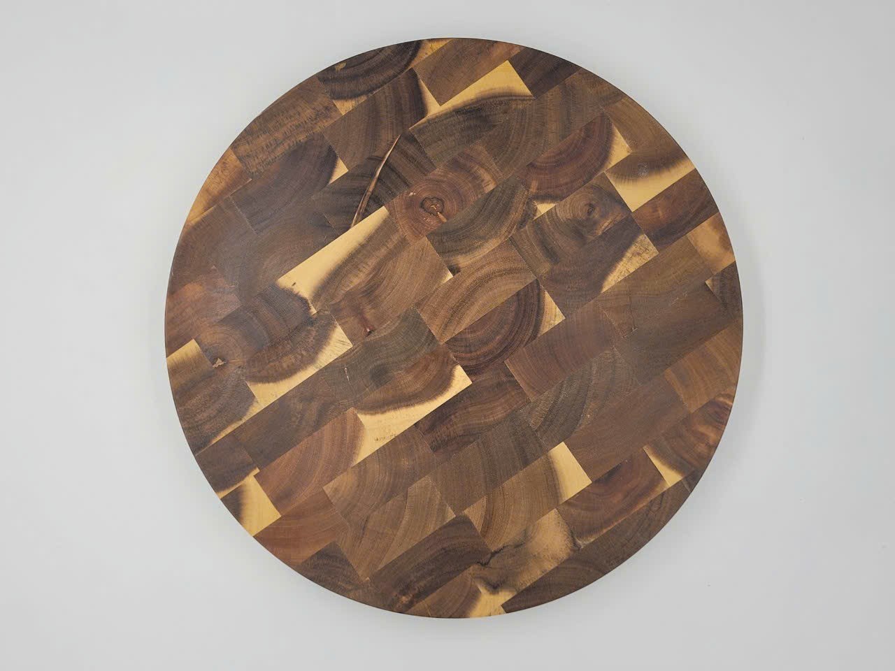 Round end-grain wooden cutting board showing block construction and natural wood grain