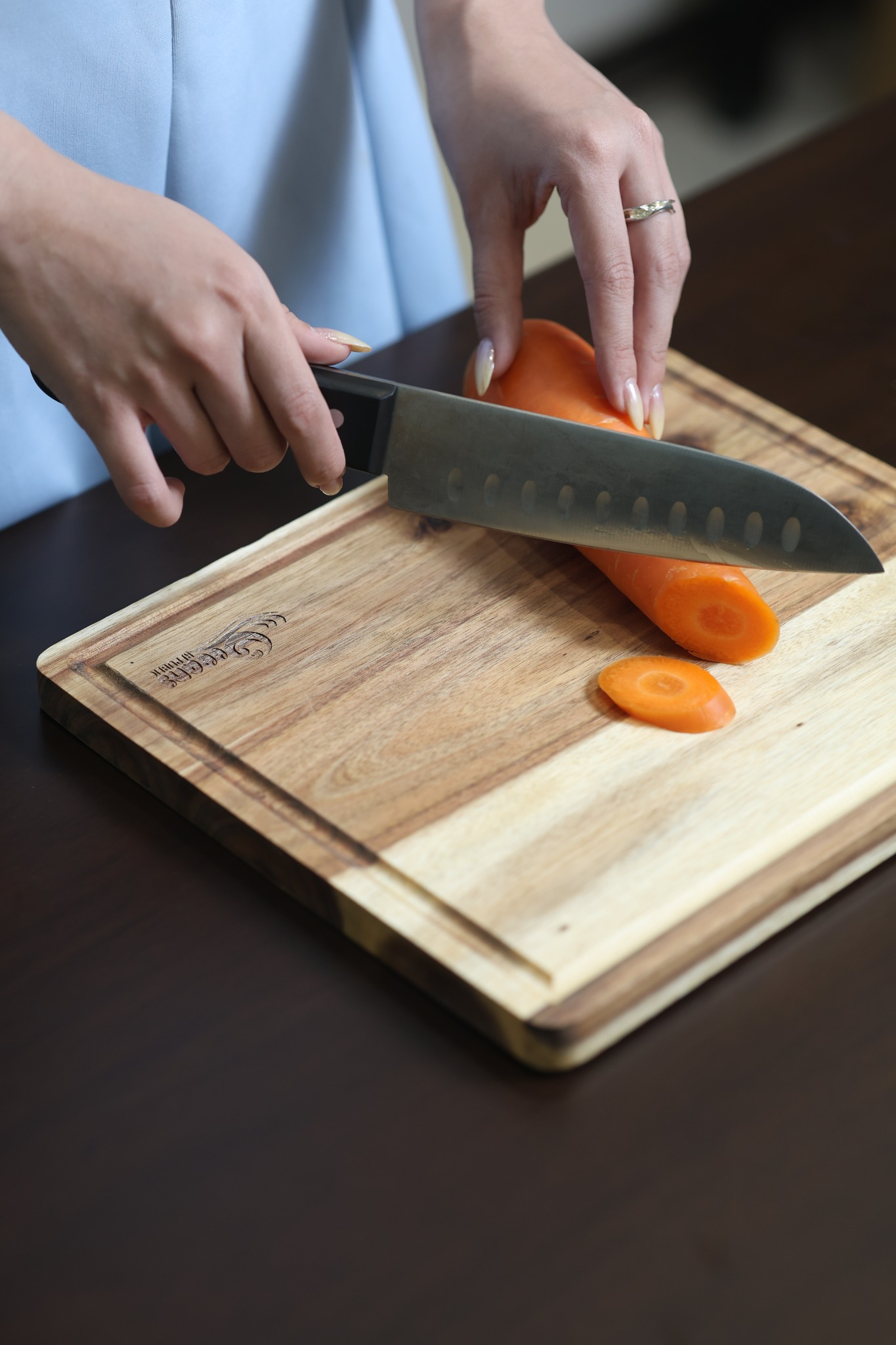 OEM logo engraving on a custom wooden cutting board during food preparation